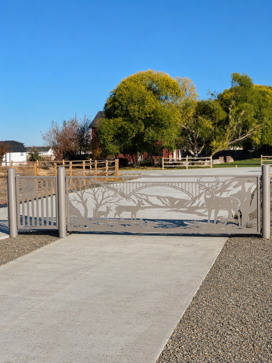 Dual driveway gates with CNC-cut deer, trees, Perrine Bridge and mountain scene panel